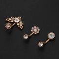 Detailed view of three gold titanium belly rings featuring sparkling clear cubic zirconia - Simple Single Heart / Gold