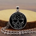 Collana gotica con teschio nero e stelle bianche presentata su base di legno naturale - Teschio stellato / Argento