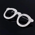 Dettaglio della spilla a forma di occhiali argento con strass su sfondo nero lucido - Argento
