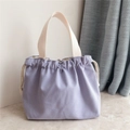 Detail of lavender canvas handbag with drawstring closure and cream cotton straps - Light Purple
