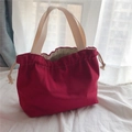 Dettaglio della borsa a mano in tela rossa con coulisse e manici in cotone beige - Borgogna