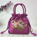 Close-up of purple satin drawstring bag with elegant floral ribbon embroidery and handle - Rose Purple