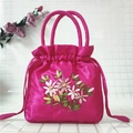 Detail view of rose red satin drawstring bag featuring intricate ribbon floral embroidery - Rose Red