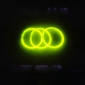 Three glowing yellow fluorescent bracelets overlapping on a black background - Yellow