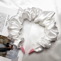 Dettaglio del cerchietto in raso plissettato bianco con punte rosa su sfondo di seta - Bianco