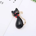 Detail of a cute black enamel cat brooch with golden edges and a sparkling red rhinestone bow - 25# Red Tie Black Cat