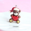Macro view of a 2.5x3cm brown resin Christmas bear pendant with a red heart and glitter - Style 31-Christmas Bear with Heart