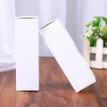 Dos cajas de regalo rectangulares de papel blanco para cosméticos en mesa de madera - 30x30x140mm / Blanco