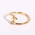 Macro di un anello dorato aperto con dettaglio freccia e gemma rotonda gialla - Sagittario - Oro