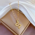 Gold titanium necklace with a crystal-encrusted snake pendant and green gem eyes - Gold Snake Pendant Style (E533)