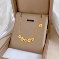 Vista detallada de seis colgantes florales en un collar de acero de titanio dorado en su caja - Dorado (M113 Dorado)