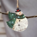 Vintage metal snowman ornament with green scarf hanging on a festive branch - Green Snowman