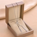 Rose gold pull-chain necklace with hollow triangle pendants over a jewelry box - Silver