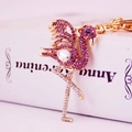 Golden crane keychain with purple crystals and large rhinestone on a pink background - Purple