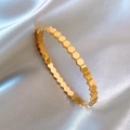 Minimalist gold honeycomb bangle with polished hexagonal design on grey silk - Gold