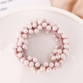 Détail macro d'un élastique à perles roses sur plateau céramique avec tissu en soie - Lavande