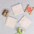 Three beige velvet jewelry pouches with snap buttons on a shimmering silver background - Double-sided Plush Style (Beige) / 7x7cm