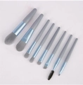 Flat lay of 8-piece mini makeup brush set with gray bristles and blue gradient handles - Blue-gray 8-piece Portable Makeup Brush Set