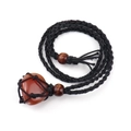 Macro detail of natural reddish-brown raw stone in handcrafted black woven necklace pouch - Red Agate