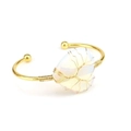 Macro detail of handmade tree of life wire-wrapped opal stone on gold open cuff bracelet - Opal