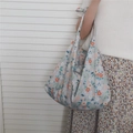 Detailed close-up of blue floral cotton tote bag with adjustable shoulder bow straps - Light Grey Base Orange-Pink Small Flowers