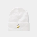 Close-up of white knitted beanie featuring detailed yellow banana embroidery on the cuff - Banana / White
