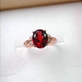 Detailopname van een ovale rode granaat ring in roségoud met diamantaccenten in bladvorm - Verstelbaar Open / Roségoud