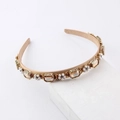 Elegant vintage gold headband with amber rhinestones and pearls on a white stand - Champagne