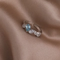 Makroaufnahme silberner Ring mit blauem Tropfenstein und Zirkon auf brauner Seide - Wassertropfen Design (Silber) (21700B)