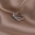 Close-up of shell flower ring with iridescent stones on champagne silk fabric - Blue Rhinestone Twisted (Silver) (21702D)