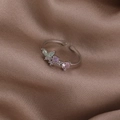 Detailed close-up of shell flower ring with green and pink gemstones on brown silk - Pink Rhinestone Butterfly (Silver) (21699C)
