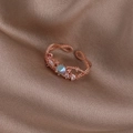 Detail of rose gold open ring with crystals and zircon on beige silk fabric - Blue Rhinestone Twisted (Rose Gold) (21702B)