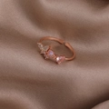 Details des roségoldenen Blumenrings mit rosa Herzstein auf braunem Seidenhintergrund - Rosa Strass Schmetterling (Roségold) (21699A)