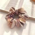 Plaid scrunchie hair tie in orange and purple tones on a decorative book background - Mixed Color Cotton Plaid
