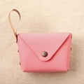Detailed macro view of a pink envelope style mini coin purse with gold button and hand strap - Rose Red