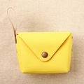Detail of yellow macaron coin purse with bronze snap button and slender leather strap - Yellow
