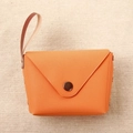 Detail of vibrant orange leather coin purse with bronze snap button on burlap background - Orange