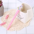 Pink cartoon unicorn gel pen with rainbow mane leaning against a white pen holder - Light-up Rouge Unicorn Pink
