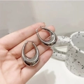 Prise de vue des boucles d'oreilles gouttes creuses en argent poli et surface miroir - Couleur Acier