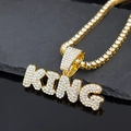 Close-up of gold KING letter pendant with sparkling rhinestones on a dark reflective surface - Gold Pendant (Letter KING) + Single Row Tennis Chain 50CM
