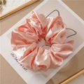 Detail of pink satin silk scrunchie with soft pearl luster and dense pleated texture - Pink