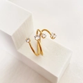 Detail eines 18 Karat vergoldeten Spiralrings mit vier funkelnden weißen Zirkonia - US 6 / C-Gekreuzte Multistein Stil Gold