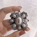 Spilla barocca vintage con perle e cristalli su base argentata tenuta in mano - Croce di Perle Quadrate Barocche