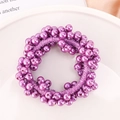 Close-up of a purple pearl hair tie on a white porcelain plate with a clean background - Purple