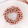 Detailed close-up of pink imitation pearls and elastic cords for elegant hair styling - Light Red