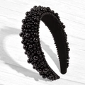 Close-up of wide black padded headband featuring dense glossy pearl embellishments on wood - Black / US 13.5