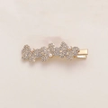 Detail of a golden butterfly hair clip featuring white rhinestones and elegant pearls - Three Rhinestone Pearl Butterfly Style