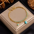 Double-layered gold titanium steel bracelet with blue turquoise beads on silk background - Gold