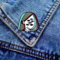 Detail of surreal enamel brooch with multiple eyes pinned on a blue denim jacket - Multi-eye Face