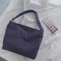 Macro shot of large purple canvas tote bag with wide shoulder straps on a soft white background - Purple